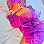 baby, infant, purple_dress, bow, pacifier, beaded_clip, blanket, lying_down, cute, newborn, soft_texture, face, headband, sleepy, child, adorable, indoors, closeup, person, toddler