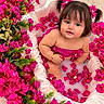 baby, child, infant, portrait, flowers, pink_flowers, floral, bouquet, satin, blanket, bath, petals, brown_hair, pigtails, hair_bows, smiling, sitting, indoor, colorful, closeup