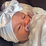 Emilie a rejoint le concours — aidez-le/la à gagner de superbes lots ! baby, pacifier, white_bow, headwear, blanket, car_seat, soft_fabric, infant, closeup, face, sleepy, child, cute, newborn, comfort, relaxed, indoors, seatbelt, portrait, clothing