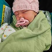 Estelle is registered to the contest to win money with this photo: baby, sleeping, blanket, pink_hat, pacifier, infant, cozy, closeup, child, cute, soft, warm, car_seat, knit, peaceful, wrapped, adorable, resting, portrait, newborn