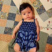 Estelle is registered to the contest to win money with this photo: baby, barefoot, blue_clothing, child, comfort, curious_expression, cute, face, hair, indoors, infant, lying_down, patchwork_quilt, patterned_fabric, portrait, relaxed, romper, skin, towel, young_child