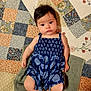 baby, barefoot, blue_clothing, child, comfort, curious_expression, cute, face, hair, indoors, infant, lying_down, patchwork_quilt, patterned_fabric, portrait, relaxed, romper, skin, towel, young_child