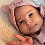 baby, infant, face, hand, pink_hat, knitted, bow, soft_texture, close_up, cute, child, portrait, warm_lighting, cozy, fluffy_background, skin, newborn, expression, young_child, sleepwear