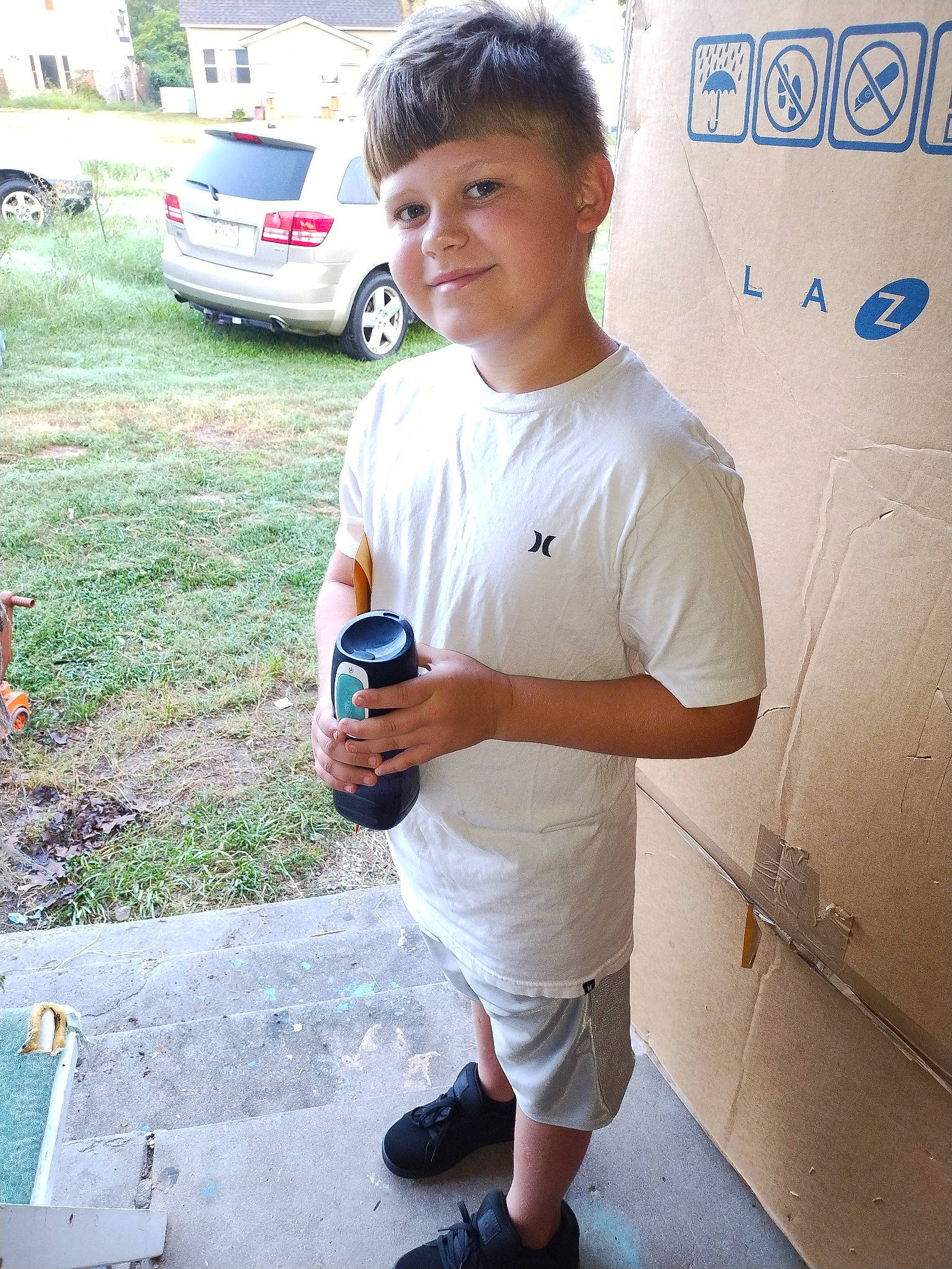 Atticus is registered to the contest to win money with this photo: asphalt, automotive_exterior, car, family_car, fun, happy, joy, leisure, motor_vehicle, person, plant, recreation, road, shorts, smile, t_shirt, tire, vacation, vehicle, vehicle_door