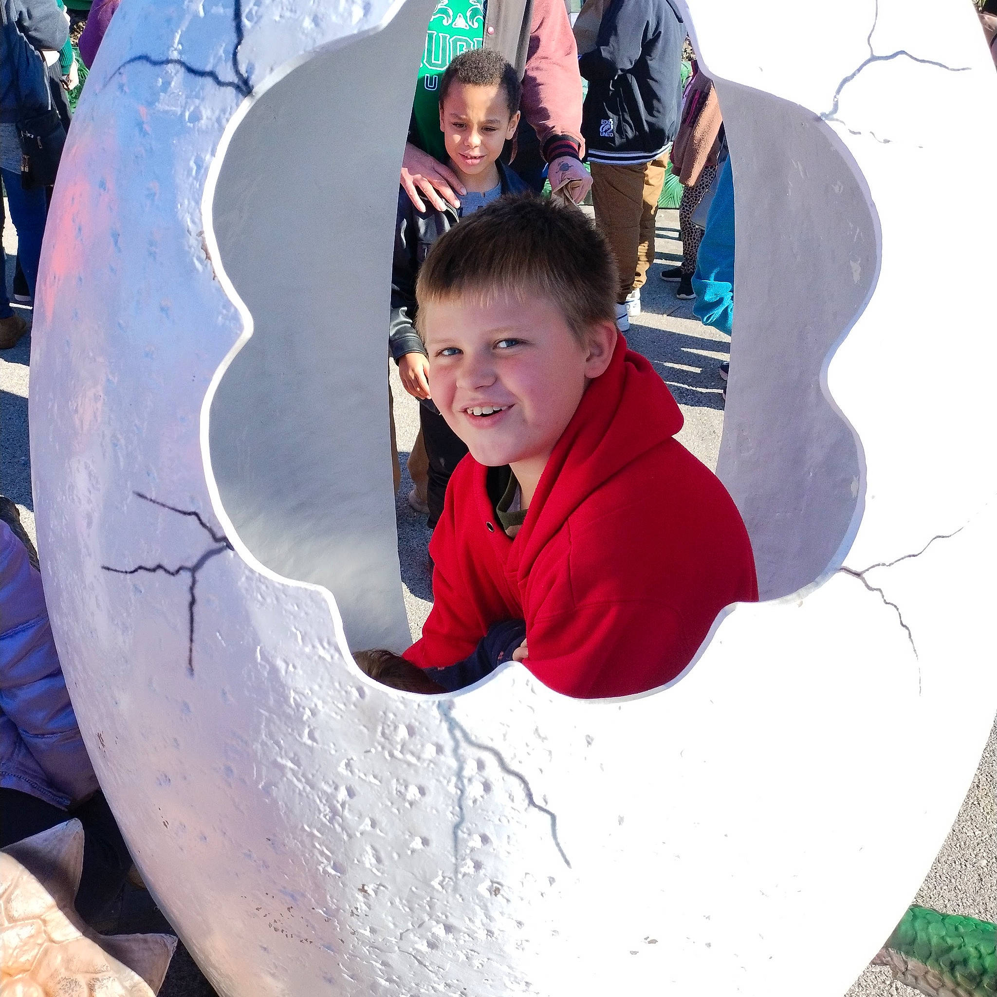 Atticus is registered to the contest to win money with this photo: child, circle, concrete, cool, freezing, fun, grass, happy, inflatable, joy, leisure, outdoor_play_equipment, person, personal_protective_equipment, play, public_space, recreation, smile, t_shirt, toddler