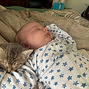 Skylynn joined the competition — help win amazing prizes! baby, kitten, sleeping, bed, blanket, onesie, stars_pattern, animal, pet, cozy, rest, child, furniture, indoor, cute, nap, face, peaceful, hand, soft