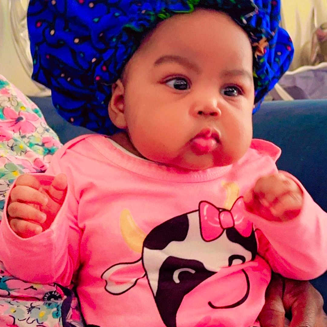 Iyanu is registered to the contest to win money with this photo: baby, bodypart, bonnet, cap, clothing, coat, cream, cutlery, dessert, face, finger, food, hand, hat, head, icecream, person, photography, portrait, spoon