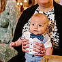 Grayson is registered to the contest to win money with this photo: baby, child, infant, bow_tie, suspenders, hands, person, adult, clothing, portrait, indoor, curious, seated, holding, black_and_white, pattern, dress, green_dress, background, warm_lighting