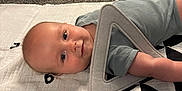 Grayson is registered to the contest to win money with this photo: baby, infant, play_mat, toy, triangle_toy, carpet, floor, blue_eyes, smile, clothing, indoor, child, face, head, skin, cute, resting, colorful, soft, playtime