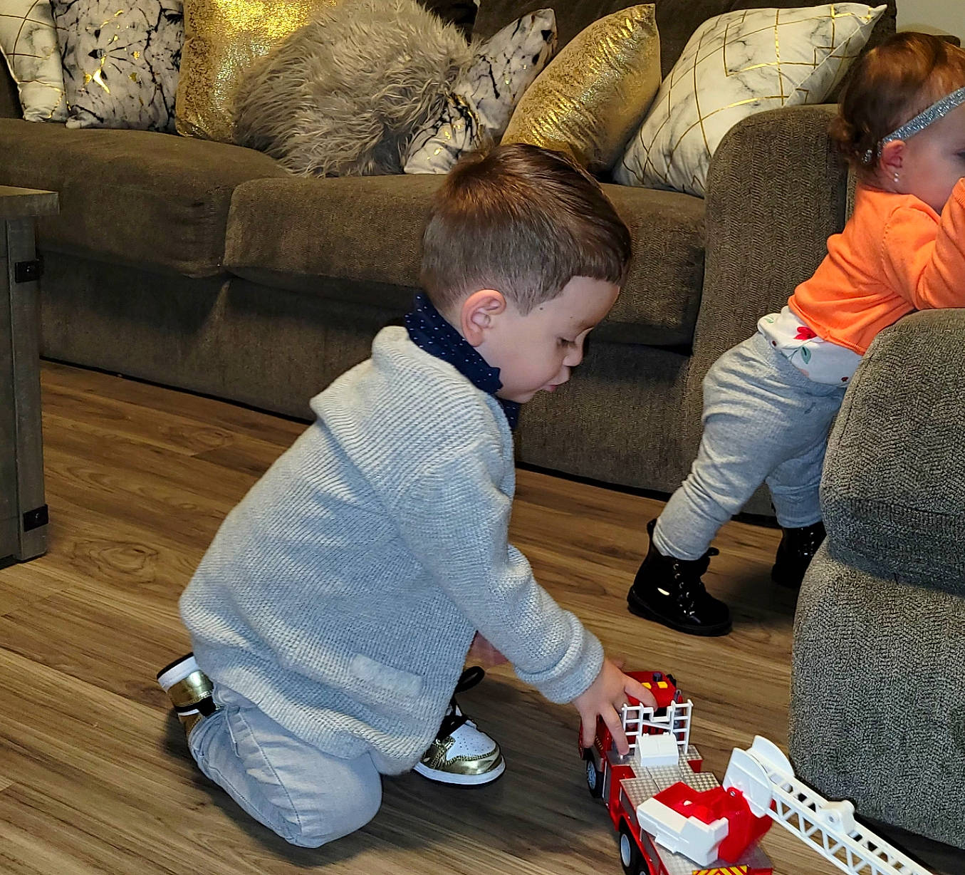 Roman joined the competition — help win amazing prizes! child, comfort, couch, floor, flooring, fun, hardwood, lap, leisure, living_room, mammal, person, sharing, shoe, sneakers, standing, t_shirt, toddler, toy, varnish