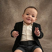 Jake joined the competition — help win amazing prizes! toddler, child, smile, suit, shorts, button_up_shirt, formal_wear, portrait, studio, seated, cute, happy, baby, person, fashion, indoor, background, expression, young_child, hands