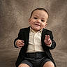 toddler, child, smile, suit, shorts, button_up_shirt, formal_wear, portrait, studio, seated, cute, happy, baby, person, fashion, indoor, background, expression, young_child, hands