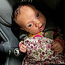 baby, infant, child, car_seat, car_interior, harness, blanket, floral_pattern, wide_eyes, portrait, sitting, travel, vehicle, head, face, hands, clothing, indoor, close_up, safe