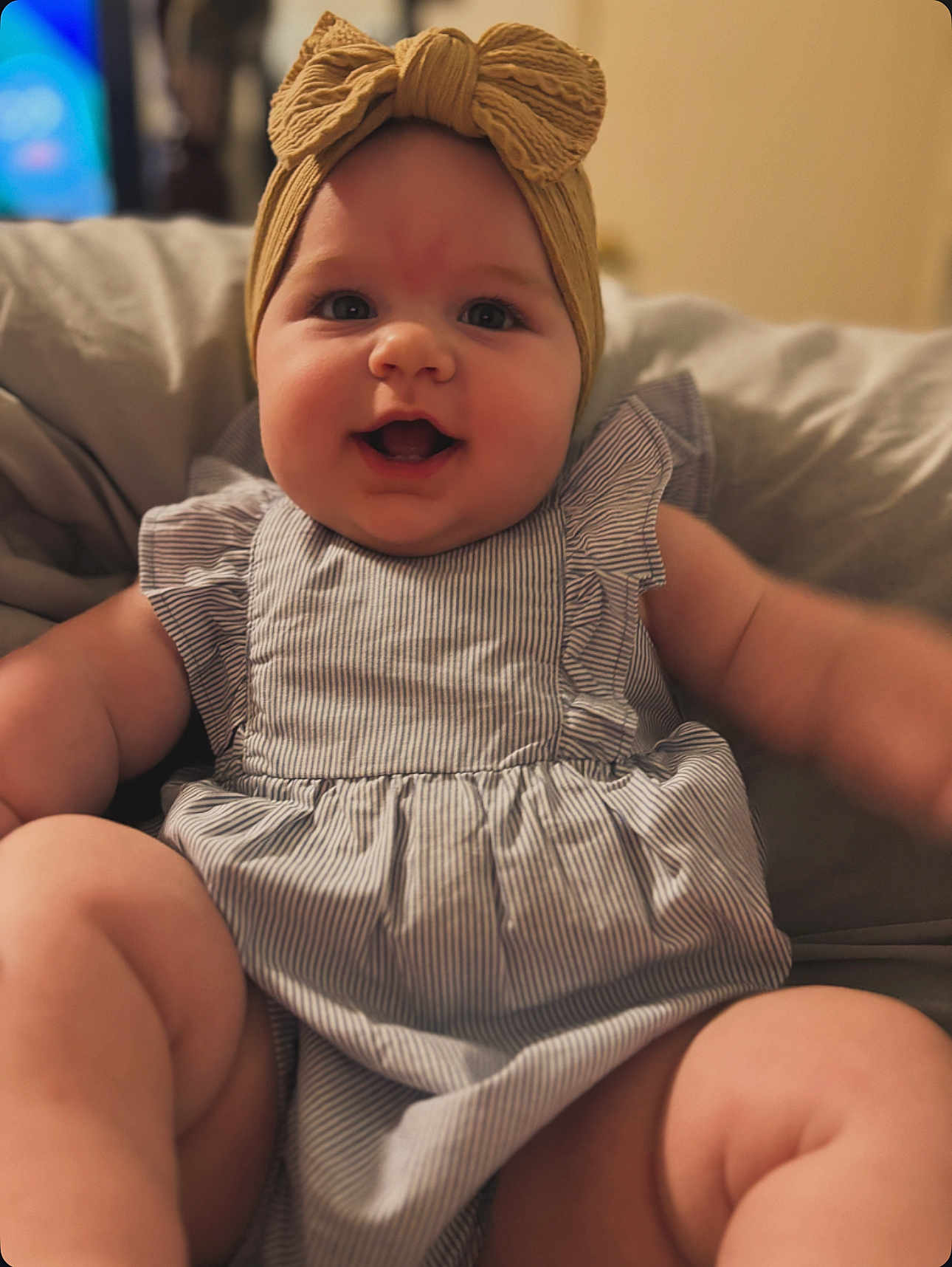 Oakleigh joined the competition — help win amazing prizes! baby, child, infant, headband, bow, smiling, happy, cute, chubby, dress, striped, sitting, indoors, soft_furniture, couch, face, portrait, closeup, skin, person