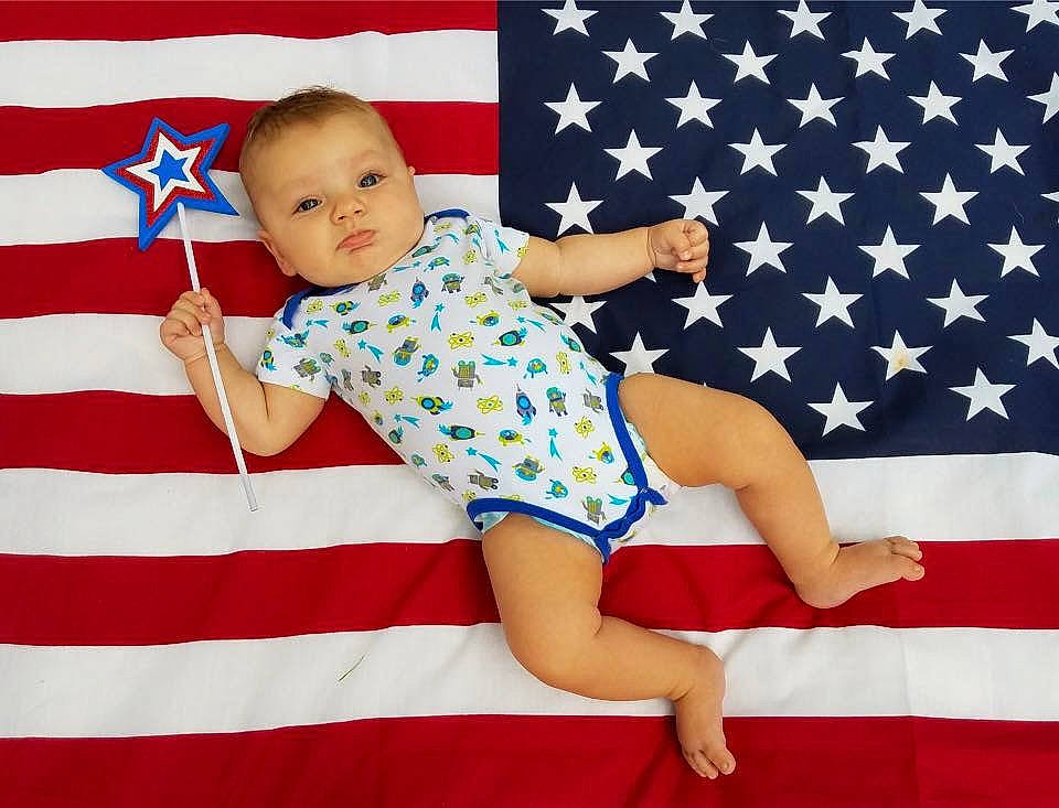 Kain is registered to the contest to win money with this photo: baby, child, flag, flag_of_the_united_states, gesture, holiday, pattern, person, textile, toddler