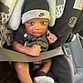 Roman is registered to the contest to win money with this photo: baby, infant, car_seat, nike, hat, mittens, black_clothing, gray_clothing, seatbelt, graco, child, indoor, portrait, cute, hands, face, eyes, seat, safety, closeup