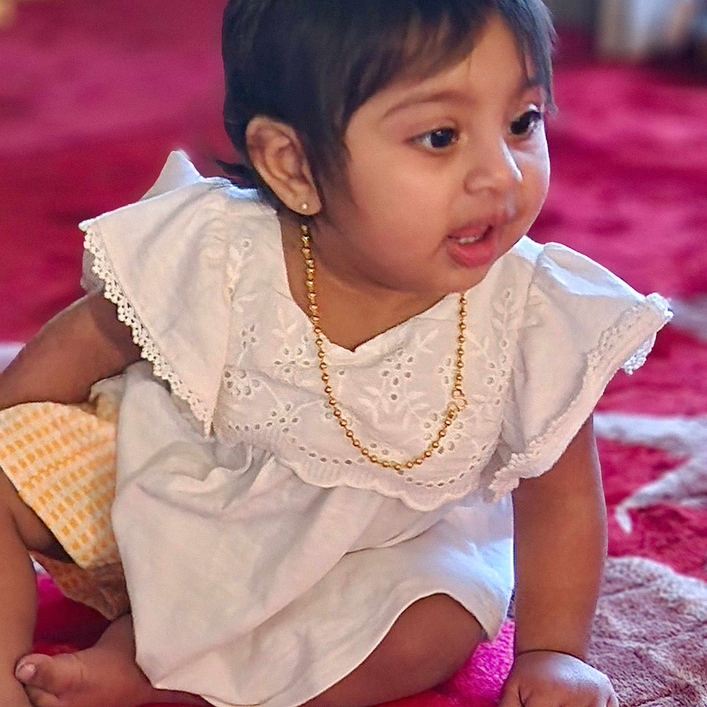 Essa is registered to the contest to win money with this photo: accessories, baby, blackhair, bodypart, clothing, crawling, dress, face, finger, hair, hand, head, jewelry, necklace, person, photography, portrait, shoulder, sitting, sleeve