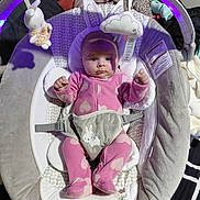 Dahlia joined the competition — help win amazing prizes! baby, infant, onesie, pink_clothing, baby_rocker, plush_toy, bunny_toy, cloud_toy, face, hands, feet, blanket, strap, indoor, curious_expression, soft_toys, purple_light, head, person, sitting