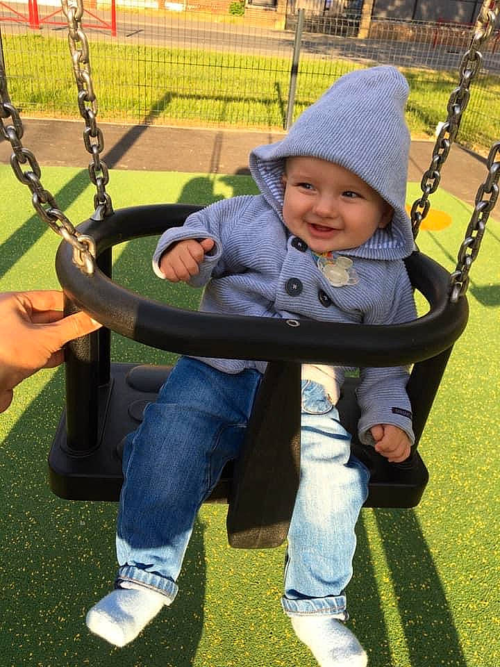 Mylan participe au concours pour gagner de l'argent avec cette photo : child, city, fun, grass, headwear, human_settlement, jeans, joy, outdoor_play_equipment, park, person, play, playground, public_space, recreation, smile, swing, toddler