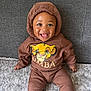 Noah joined the competition — help win amazing prizes! baby, child, smiling, hoodie, brown_clothing, simba, lion_king, carpet, couch, indoor, happy, tongue_out, cute, sitting, person, portrait, cozy, clothing, infant, young_child