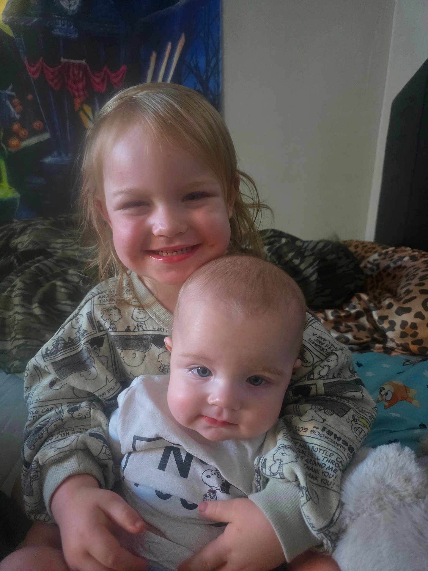 Oktober is registered to the contest to win money with this photo: child, baby, smile, hug, bed, blanket, clothing, indoor, person, cute, sitting, happy, face, head, toddler, young_child, sleepwear, plush, family, cozy