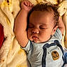Azael is registered to the contest to win money with this photo: baby, infant, sleeping, child, portrait, close_up, curly_hair, closed_eyes, peaceful, cozy, blanket, plush_blanket, bed, onesie, bear_design, raised_arm, hand, face, indoors, nap