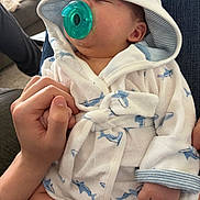 Lux joined the competition — help win amazing prizes! baby, infant, pacifier, bathrobe, shark_pattern, hand, holding, sleeping, cozy, indoor, person, cute, comfort, love, family, relaxation, skin, clothing, portrait, casual