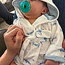 baby, infant, pacifier, bathrobe, shark_pattern, hand, holding, sleeping, cozy, indoor, person, cute, comfort, love, family, relaxation, skin, clothing, portrait, casual