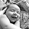 baby, smiling, sleeping, blanket, cozy, black_and_white, infant, cute, face, arm, soft_texture, portrait, resting, closeup, newborn, child, happy, peaceful, skin, nap