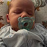baby, sleeping, pacifier, infant, onesie, bunny_print, pillow, soft_fabric, face, child, indoor, closeup, resting, cute, peaceful, newborn, comfort, head, person, sleep