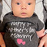 Lux is registered to the contest to win money with this photo: baby, infant, onesie, text, mother's_day, clothing, person, hand, sweater, holding, cute, expression, face, pink_heart, celebration, love, casual, indoor, portrait, newborn