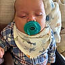 baby, bib, blanket, child, clothing, comfort, couch, cute, face, hand, indoors, infant, pacifier, people, plaid_shirt, portrait, resting, sleeping, soft, young