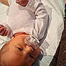 baby, infant, pacifier, white_onesie, lying_down, soft_surface, blanket, newborn, cute, child, skin, hand, foot, indoors, portrait, head, sleepwear, resting, comfort, young