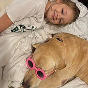 Scarlet joined the competition — help win amazing prizes! child, dog, sunglasses, bed, blanket, white, smiling, lying_down, indoor, pet, cute, relaxed, pink, accessory, comfort, happy, face, clothing, canine, human