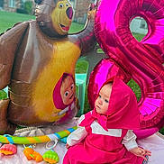 Amalia joined the competition — help win amazing prizes! baby, baby_toys, backyard, balloon, bear, birthday_party, blue_eyes, child, face, heart_balloon, hooded_clothing, infant, inflatable_toy, outdoor, pink_outfit, play_mat, portrait, seated, smiling, toys