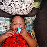 John joined the competition — help win amazing prizes! baby, bird, blanket, chewing, child, comfort, couch, crocheted_blanket, cute, face, floral, hand, indoors, infant, pacifier, pattern, pillow, playful, red_onesie, smiling