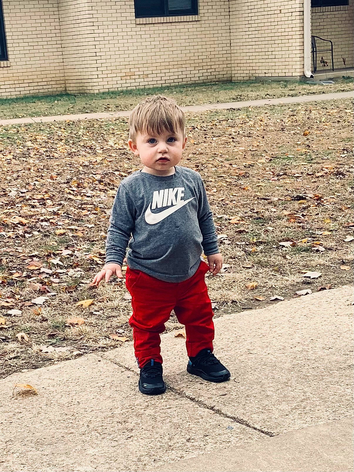 Cecil is registered to the contest to win money with this photo: asphalt, brick, brickwork, child, cobblestone, cool, denim, door, flooring, footwear, grass, outerwear, pattern, person, public_space, road_surface, sleeve, street_fashion, tints_and_shades, toddler