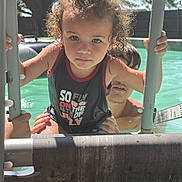 Bryson joined the competition — help win amazing prizes! child, pool, water, ladder, curly_hair, swimsuit, summer, outdoor, person, adult, supporting_hand, sunlight, backyard, fence, swimming, playing, happy, fun, family, splash