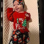 Finley is registered to the contest to win money with this photo: baby, infant, christmas_clothing, headband, bow, smile, crib, blanket, holiday, festive, red_shirt, patterned_pants, face, happy, indoors, child, cute, soft_texture, person, lying_down
