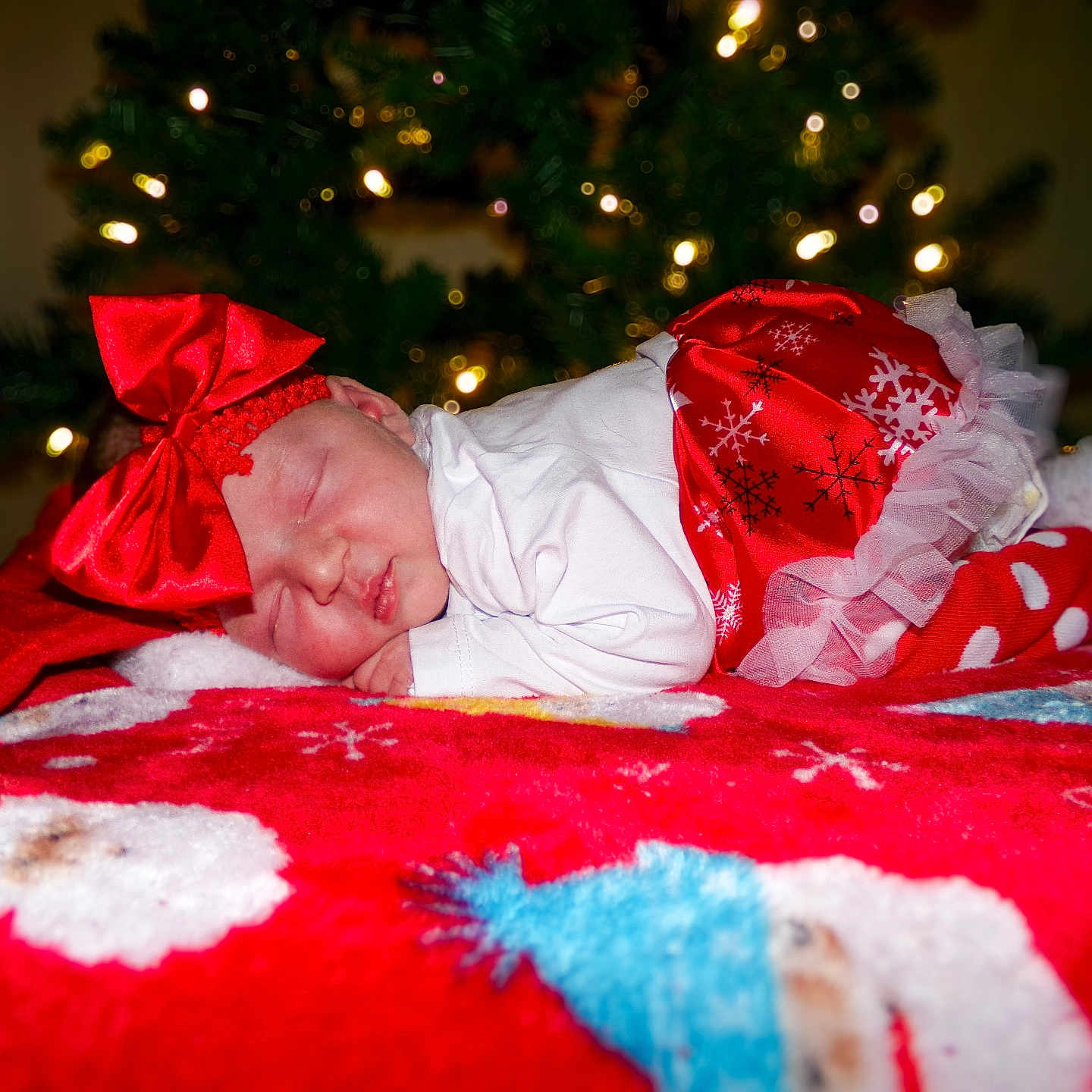 Finley is registered to the contest to win money with this photo: baby, blanket, christmas, christmas_tree, cute, festive_clothing, holiday, holiday_decor, indoors, infant, peaceful, polka_dot_socks, portrait, red_bow, red_skirt, sleep, sleeping, soft_lighting, toddler, white_shirt