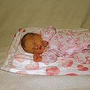 Finley is registered to the contest to win money with this photo: newborn, baby, sleeping, blanket, pink, onesie, butterfly_pattern, heart_pattern, infant, cozy, soft_lighting, peaceful, cute, child, lying_down, indoors, portrait, resting, toddler, warm