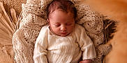 Arthur a rejoint le concours — aidez-le/la à gagner de superbes lots ! newborn, baby, sleeping, knitted_clothes, basket, blanket, cozy, soft_texture, brown, cream, infant, peaceful, portrait, indoors, wooden_floor, warm_lighting, decor, relaxation, cute, small