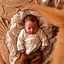 newborn, baby, sleeping, knitted_clothes, basket, blanket, cozy, soft_texture, brown, cream, infant, peaceful, portrait, indoors, wooden_floor, warm_lighting, decor, relaxation, cute, small