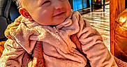 Amara is registered to the contest to win money with this photo: baby, blanket, chair, child, cozy, cute, elderly, furniture, hands, happy, home, indoor, infant, person, pink_outfit, portrait, smiling, table, warm_lighting, wooden_floor