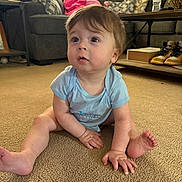 Beau joined the competition — help win amazing prizes! baby, child, infant, carpet, onesie, couch, woman, sofa, pillow, coffee_table, water_bottle, shoes, living_room, person, furniture, indoor, sitting, curious, home, casual