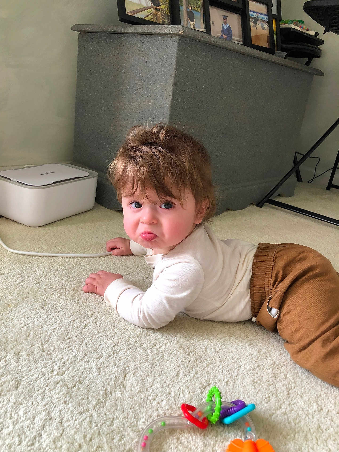 Beau joined the competition — help win amazing prizes! baby, child, pout, carpet, toy, indoor, brown_pants, white_top, face, person, crawling, hair, expression, floor, hand, footwear_absent, playtime, cute, infant, home