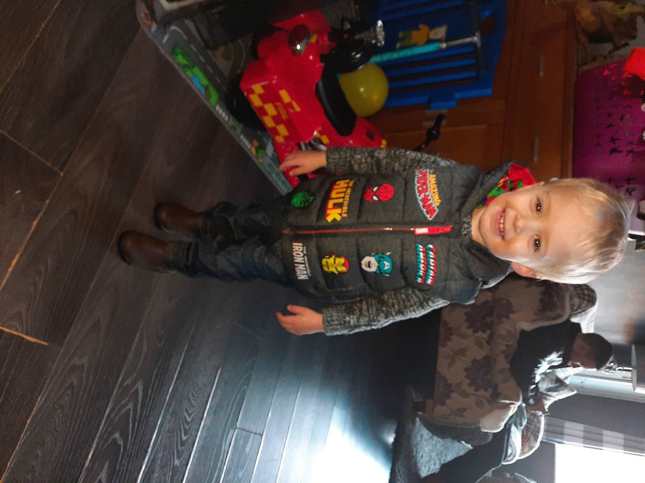 Tyler is registered to the contest to win money with this photo: baby, baby_toddler_clothing, baby_toys, child, flooring, fun, hardwood, joy, person, plastic, smile, toddler, toy, wood