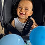 Maëlann a rejoint le concours — aidez-le/la à gagner de superbes lots ! baby, baby_toy, balloons, blue, child, child_seat, clothing, cute, expression, face, happy, indoor, infant, person, portrait, seatbelt, smiling, stroller, toy, young