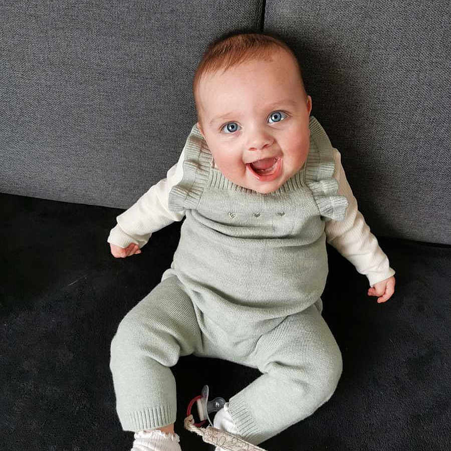 Rose a rejoint le concours — aidez-le/la à gagner de superbes lots ! baby, babylaughing, clothing, couch, face, footwear, formalwear, furniture, happy, head, hosiery, pants, person, photography, portrait, shoe, sitting, sleeve, sock, suit