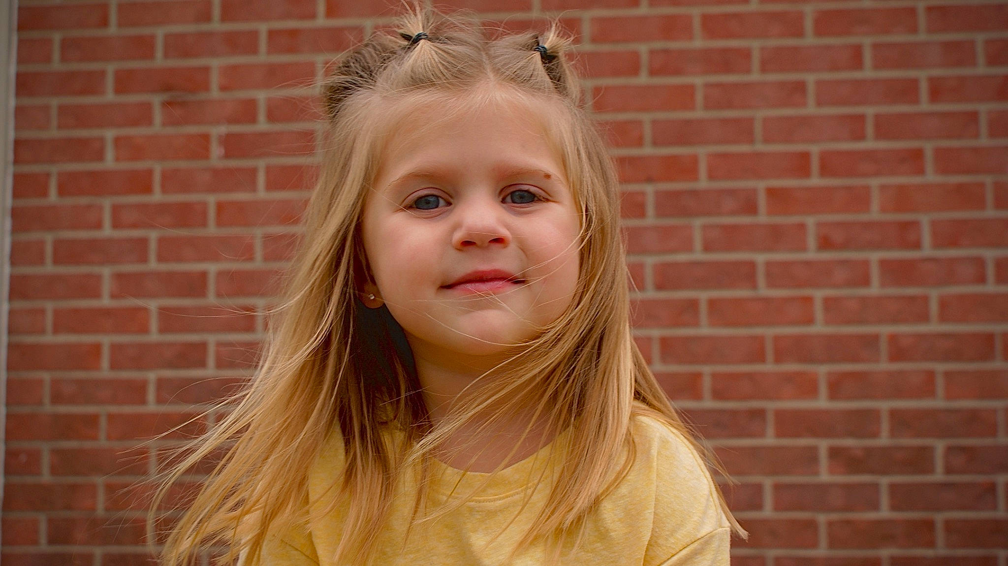 Emberleigh joined the competition — help win amazing prizes! bangs, blond, brick, brickwork, brown_hair, eyelash, flash_photography, fun, grass, happy, iris, jewellery, joy, layered_hair, lip, long_hair, neck, person, smile, toddler